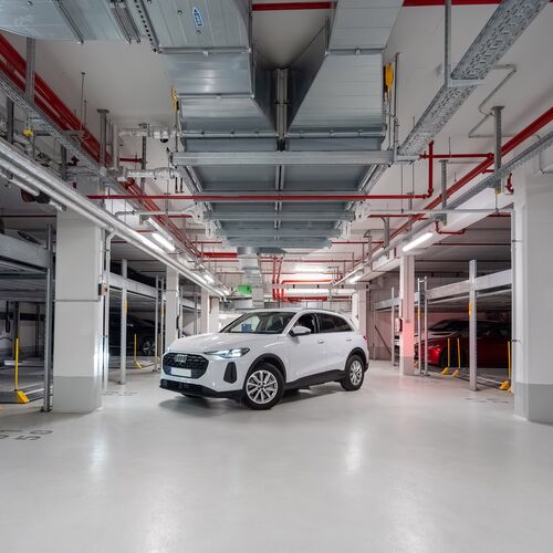 The car is parked in the aisle of the underground car park between two Combilift systems