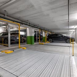 Several cars are parked on the parking platform in an underground garage.