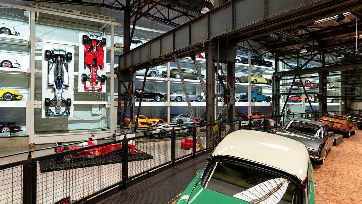 A wall-mounted shelf full of cars in a museum