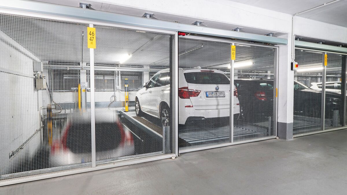 A car is being lowered on a parking system