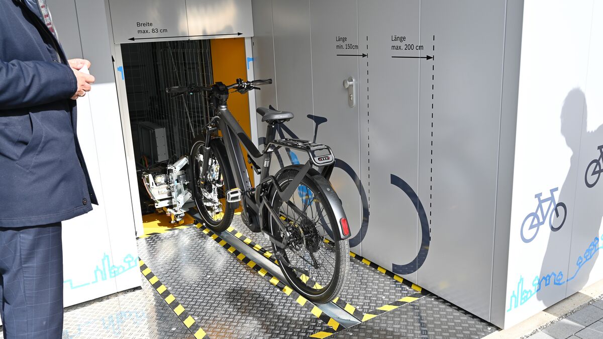 Bicycle on a guide rail in front of an automatic bicycle parking system