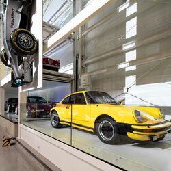 A yellow classic car parked in a parking system at a museum