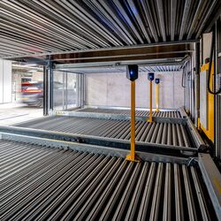 Widok wnętrza półautomatycznego systemu parkingowego WÖHR Combilift z ruchomymi platformami parkingowymi umożliwiającymi oszczędne wykorzystanie przestrzeni i efektywne parkowanie pojazdów.