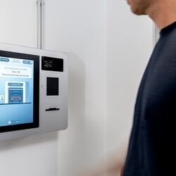 Osoba obsługuje terminal sterujący systemu WÖHR Combilift 542/543 w celu zarządzania procesem parkowania.