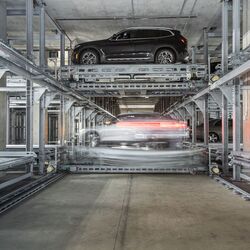 Samochód stoi na platformie parkingowej w zautomatyzowanym systemie parkingowym.